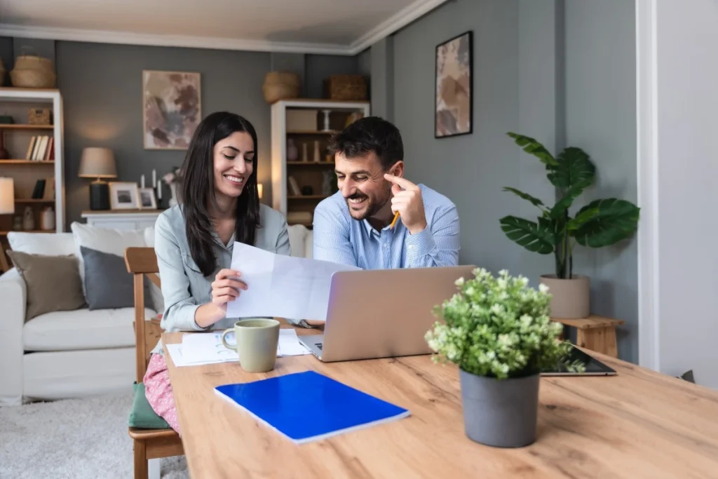 Two happy people sitting at table making an NDIS referral